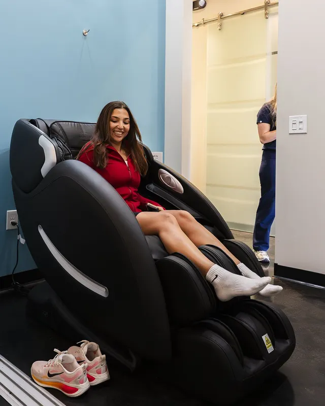 A client relaxing in a massage chair at the studio