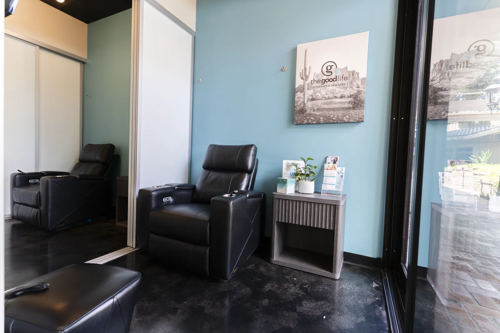 A treatment room with two black leather recliners